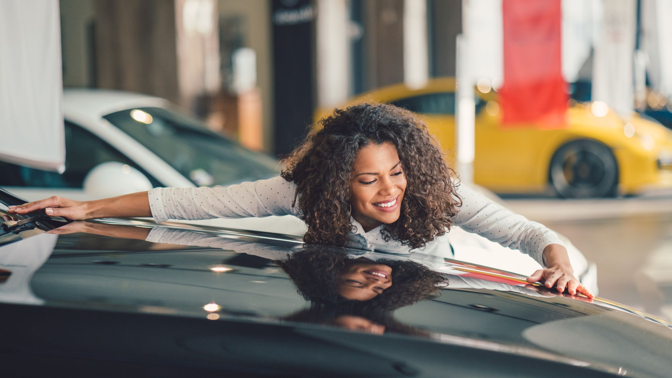 black woman hugging car