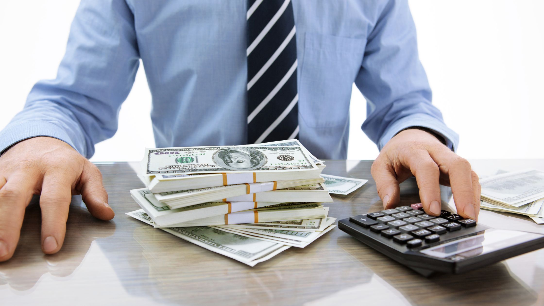 man in suit with cash and calculator